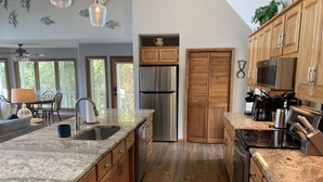 A modern kitchen with granite countertops, stainless steel appliances, wooden cabinets, and a large island. - Lakefront Retreat w/ Private Dock, Game Room & Sunset Views - Sleeps 16 (Winchester)