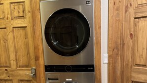 Une buanderie dotée de deux portes et équipée de deux machines à laver LG à chargement frontal.