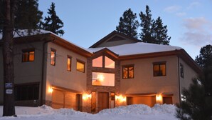 Une maison à deux étages avec une façade en pierre et un grand garage.