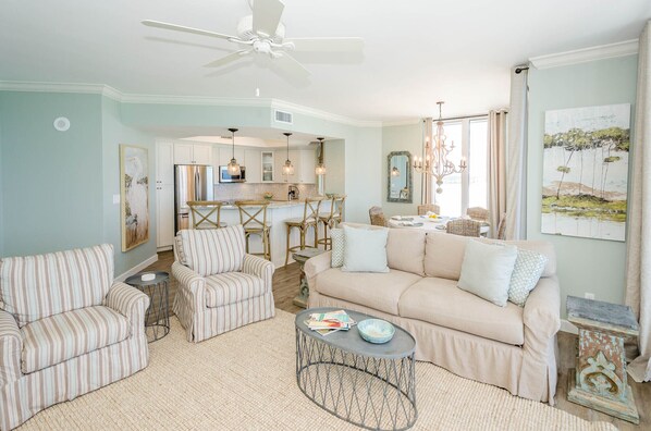 A living room with a sofa, armchairs, a coffee table, and a dining area with chairs and a table. - FIRST WEEK OF AUGUST JUST OPENED! (Destin)