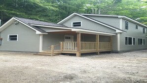 A two-story house with a covered porch and a small front yard.