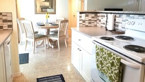 A kitchen with white cabinets, a white stove, and a tiled backsplash. - Private Heated  Pool House 6 miles from the Beach (Bradenton)
