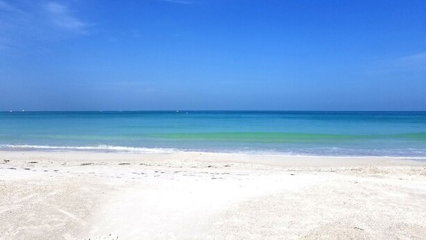 A beach with clear blue water and a sandy shore. - Private Heated  Pool House 6 miles from the Beach (Bradenton)