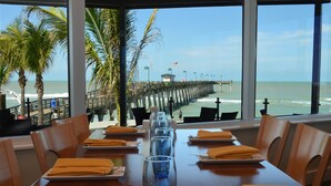 Un restaurant avec vue sur l’océan et une jetée.