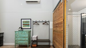 A bathroom with a wooden floor, a green dresser, a bench, and a shower area. - Contemporary Chic │West Side │Walk Everywhere │Hot Tub │One Block to River (Bend)