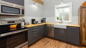 A modern kitchen with a microwave, stove, and dishwasher. - Contemporary Chic │West Side │Walk Everywhere │Hot Tub │One Block to River (Bend)