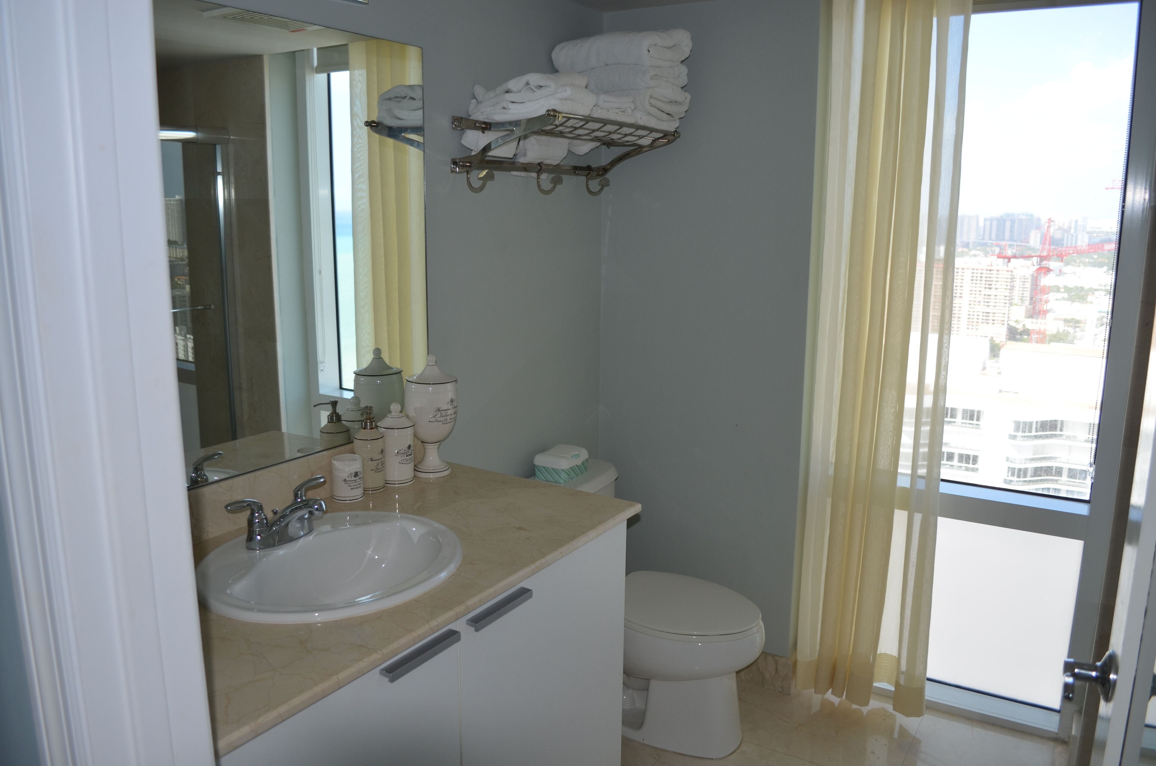A bathroom with a sink, mirror, and a towel rack.