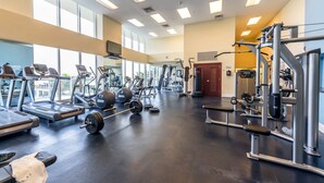 A spacious gym with treadmills, weight machines, and free weights.