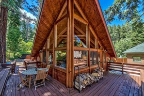 A wooden cabin with a large deck, built-in seating, and a view of the surrounding forest. - 3 Bdrm Quintessential Cabin in the Woods On a Creek Sleeps 5 (IVGID)