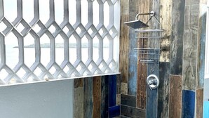 A modern shower enclosure with a wooden panel design and a metal showerhead.