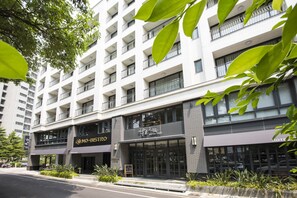Hotel de diverses plantes amb balcons, un restaurant i un rètol que diu 'Hotel Kuri'.