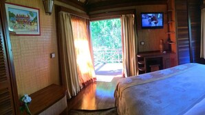 Een kamer met een bed, een televisie en uitzicht op de omgeving.