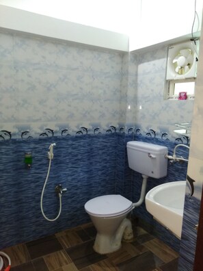 A bathroom with a toilet, sink, and shower.