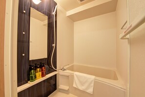A modern bathroom with a shower, a mirror, and a shelf with toiletries.