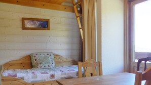 A wooden bed with a quilt, a wooden table, a chair, a ladder, and a picture on the wall. - Quiet studio with balcony, parking and pets allowed (Méribel)