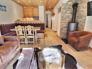 Ein gemütliches Wohnzimmer mit einer Couch, einem Holzesstisch und einem Kamin.