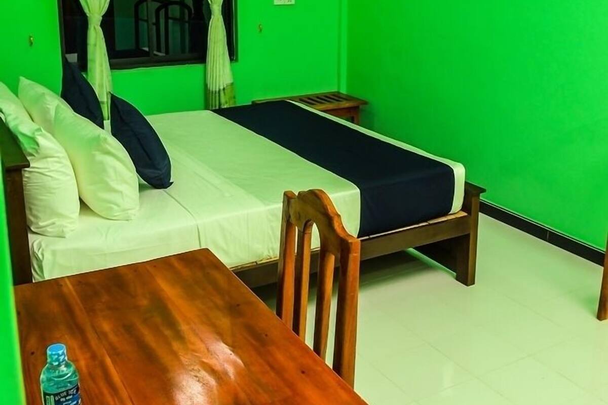 Une chambre avec deux lits, une table et une chaise.