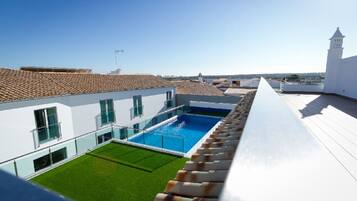 Una piscina al aire libre de temporada, sombrillas