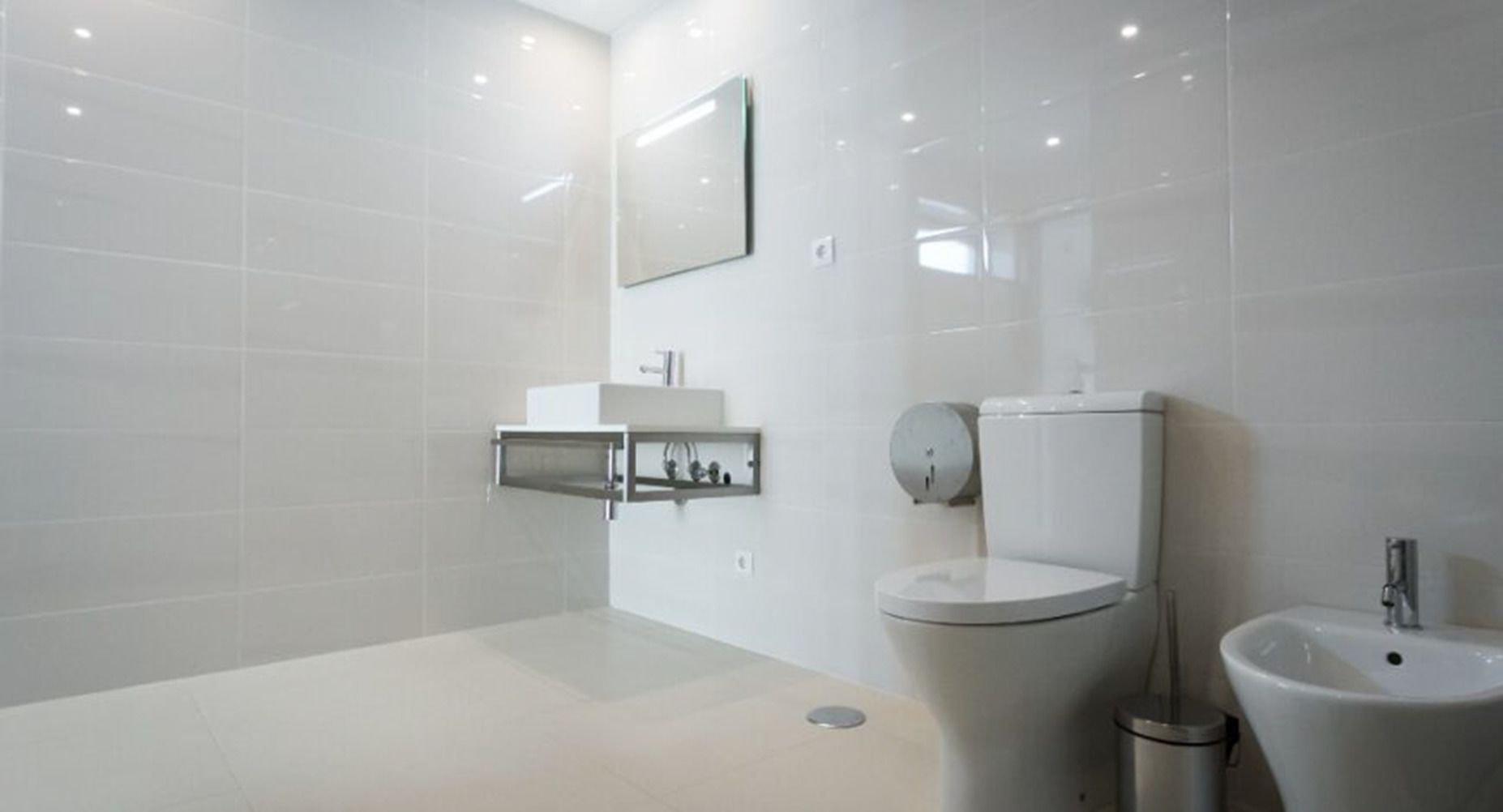 A modern bathroom with a toilet, bidet, and sink.