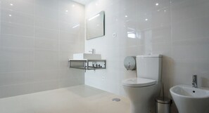 A modern bathroom with a toilet, bidet, and sink. - Peralux (Silves)
