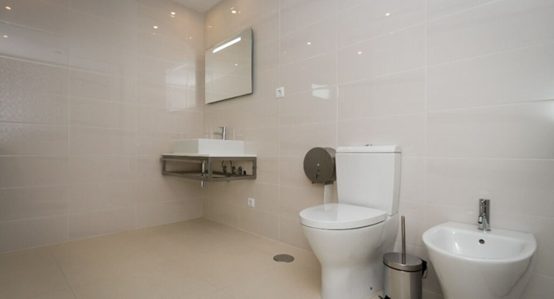 A modern bathroom with a toilet, bidet, and sink.