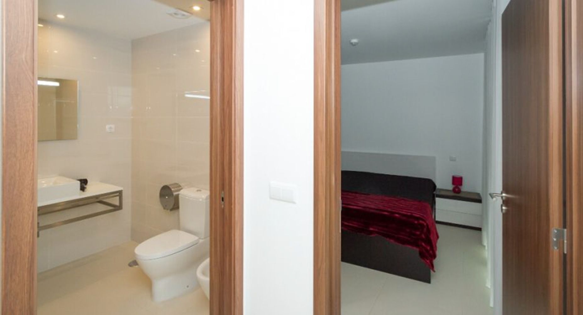 Et badeværelse med toilet, vask og spejl.
