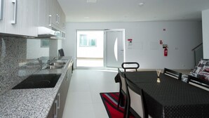 Una cucina moderna con ripiani in granito, elettrodomestici in acciaio inossidabile e un'area pranzo con tavolo e sedie.