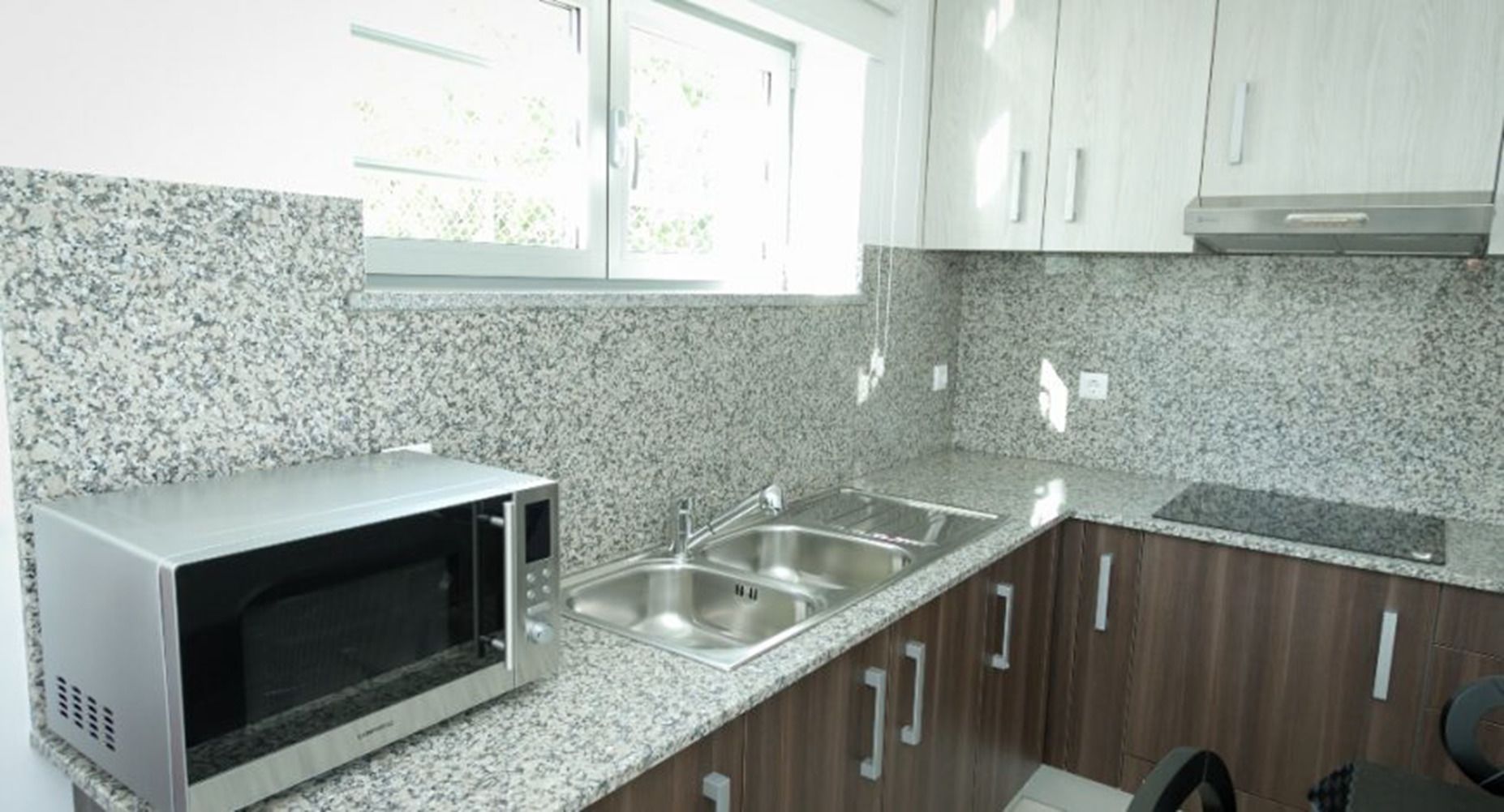 Una cocina con encimeras de granito, electrodomésticos de acero inoxidable y armarios de madera.