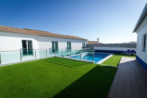 Una piscina al aire libre de temporada, sombrillas