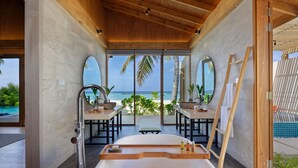 Une salle de bain moderne avec une grande baignoire, des éléments décoratifs en bois et une vue sur l’océan.