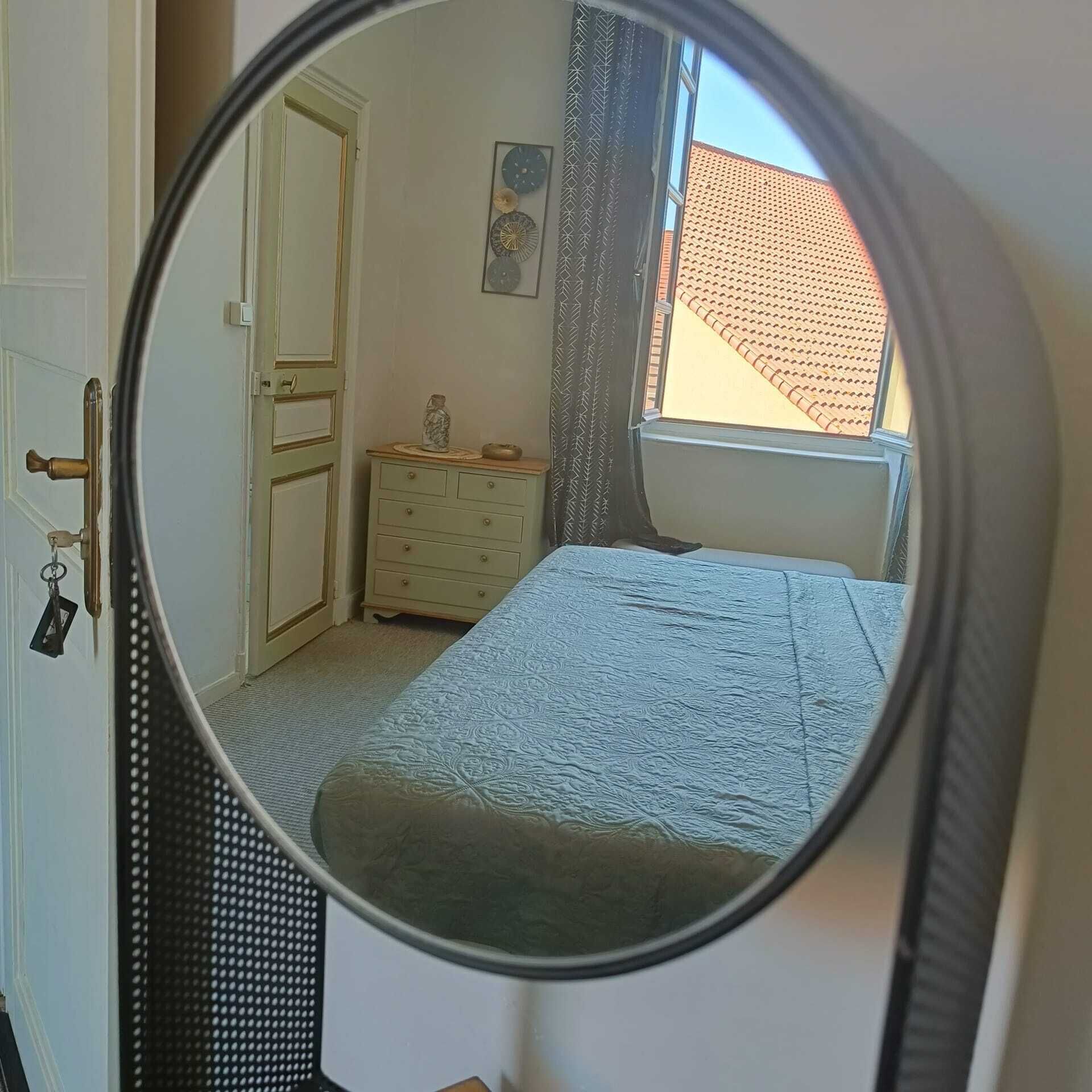 Un dormitorio con cama, cómoda y ventana con vista a un edificio.