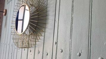 A wall-mounted mirror with a sunburst design.