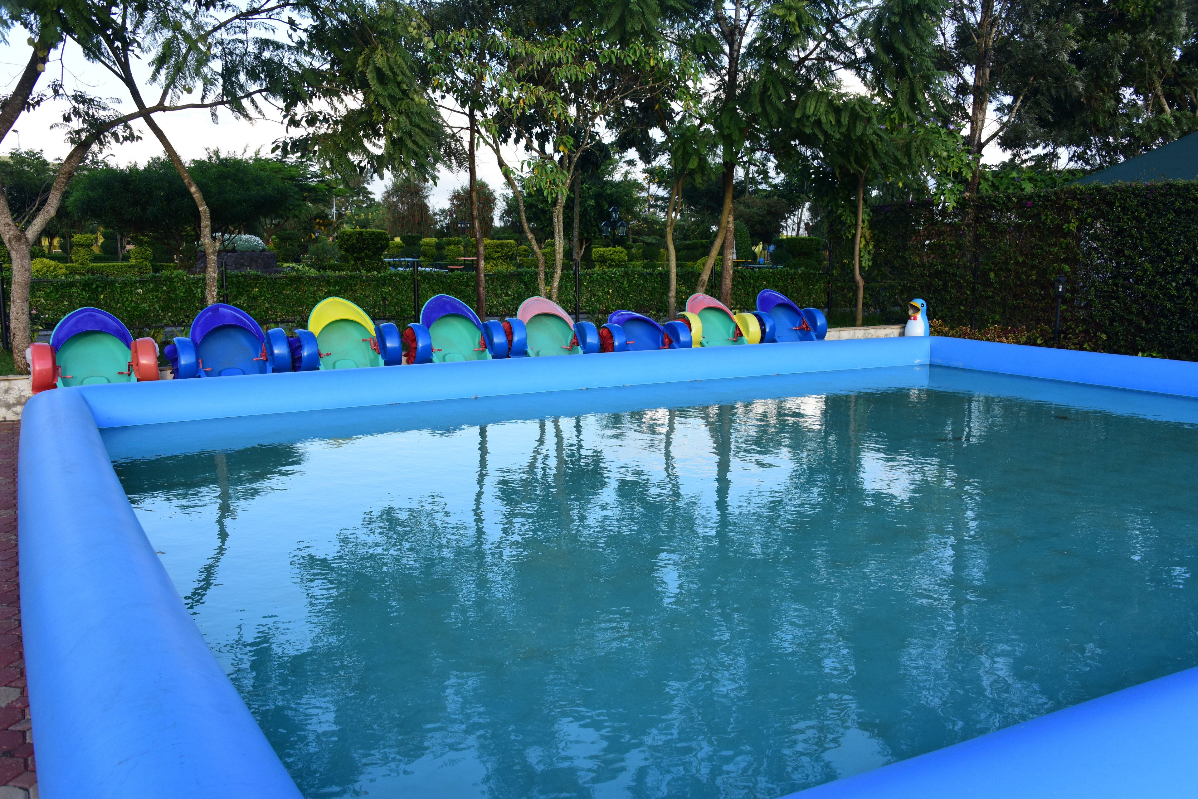 Una piscina con varias tablas de salto coloridas y una superficie de agua azul cristalina.