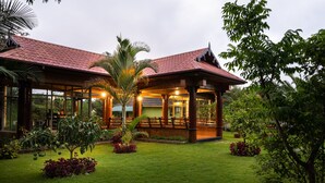 A traditional-style building with a red tiled roof, large windows, and a covered outdoor seating area.