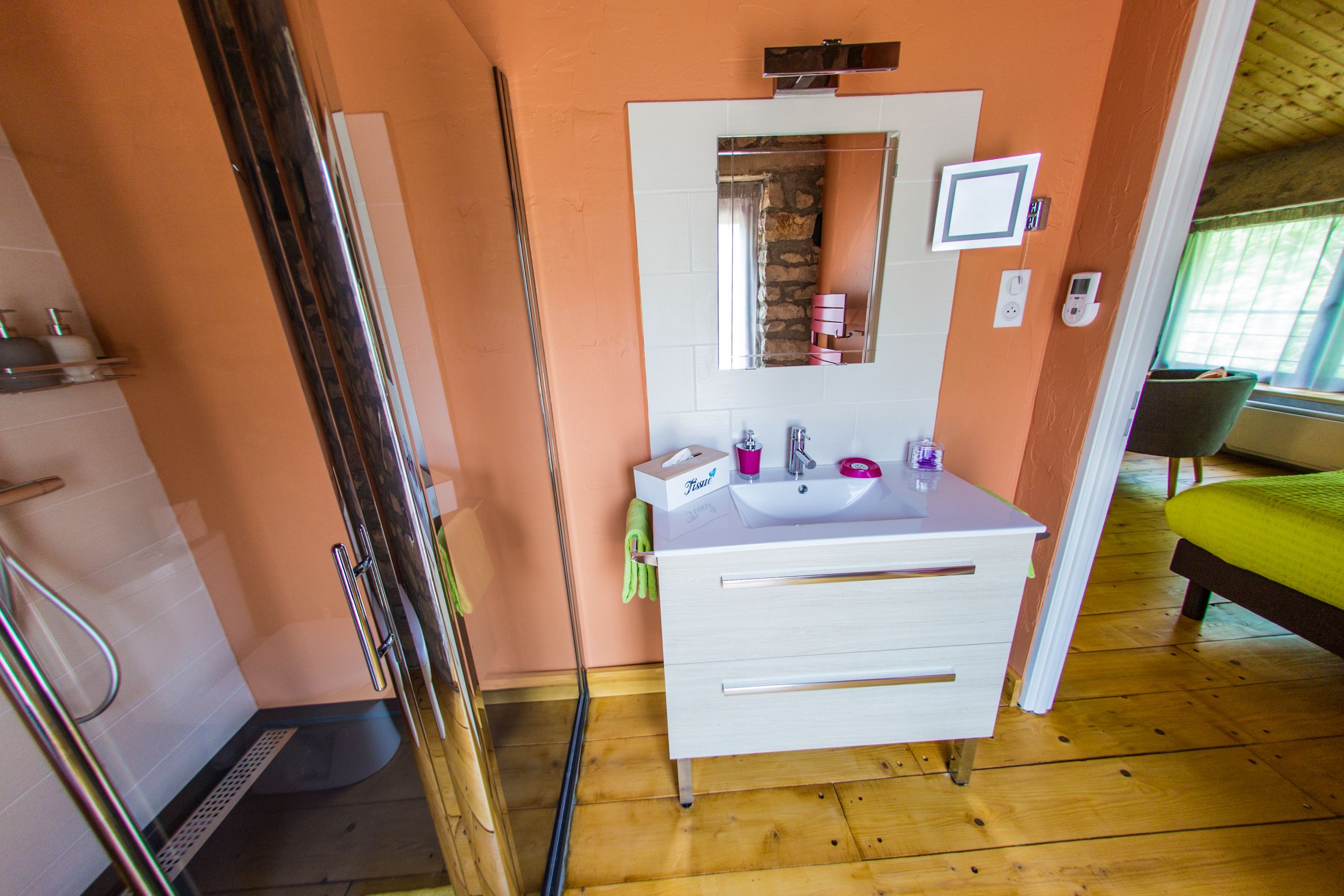 Un baño con tocador blanco, un espejo, un lavabo y una ducha.