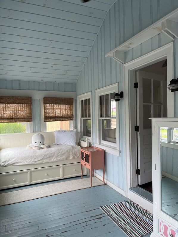 A bedroom with a bed, a nightstand, and a wardrobe. - Classic Beach Cottage, Steps to Ocean Break. (Narragansett)