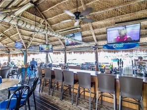 Relax with a cold drink at our outdoor bar, featuring comfortable seating and a TV for live sports.