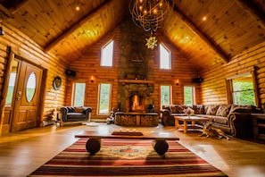 A log cabin interior with a fireplace, wooden furniture, and a dog. - The Cabin that brings people together (Bridgewater)