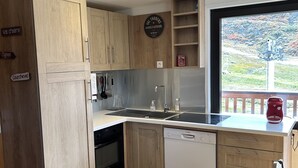 Una cocina moderna con armarios de madera, lavavajillas y ventana con vistas panorámicas.