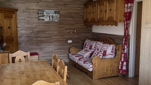 Una cocina acogedora con armarios de madera, una mesa de comedor de madera y un sofá.