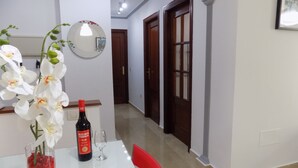 Een eetgedeelte met een witte tafel, een fles Málaga Virgen wijn, een glas en witte orchideeën.