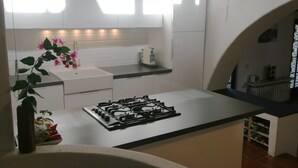 A modern kitchen with white cabinets, a gas stove, and a countertop. - Centrally located, yet secluded house on the outskirts of Dolcedo (Dolcedo)