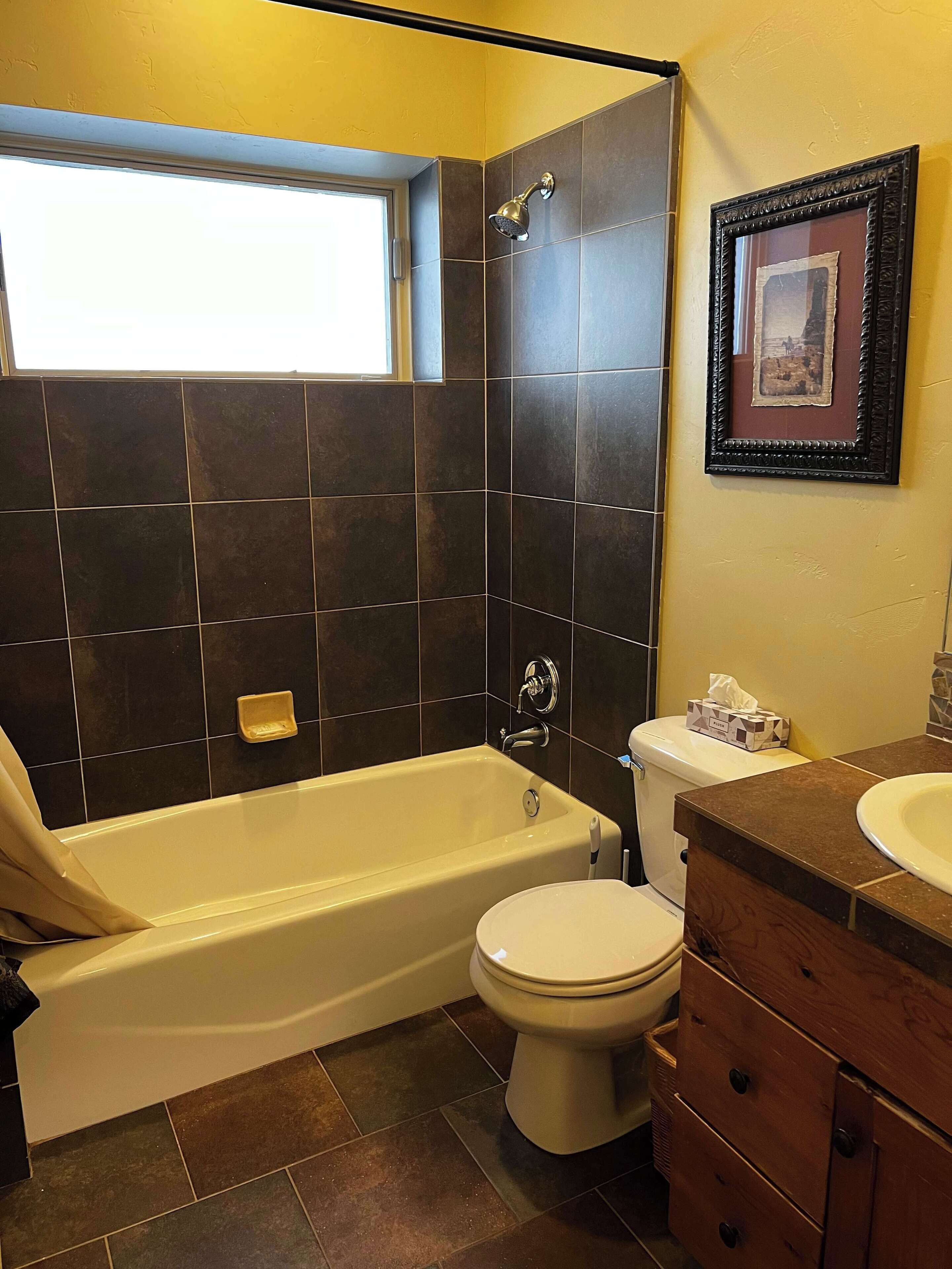 A bathroom with a bathtub, toilet, and sink.