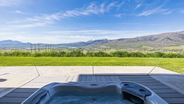 Un bain à remous avec vue sur les montagnes et un champ verdoyant.