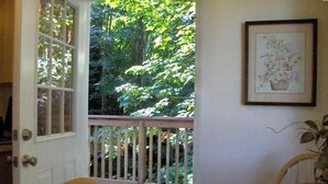 Une pièce avec une terrasse en bois, une table à manger et des chaises.