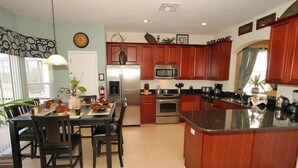 Una cocina moderna con armarios de madera, electrodomésticos de acero inoxidable y una isla central.