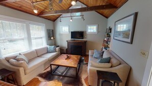 A living room with a fireplace, two sofas, a coffee table, and a TV. - Stunningly Remodeled Historic Home Near Downtown (Bozeman)