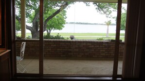 A view through a window with a brick wall and a lawn.