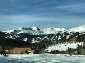 Paisaje montañoso con picos nevados y una zona de estación de esquí en primer plano.