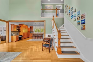 Un intérieur spacieux avec un escalier en bois, un coin repas et une cuisine.
